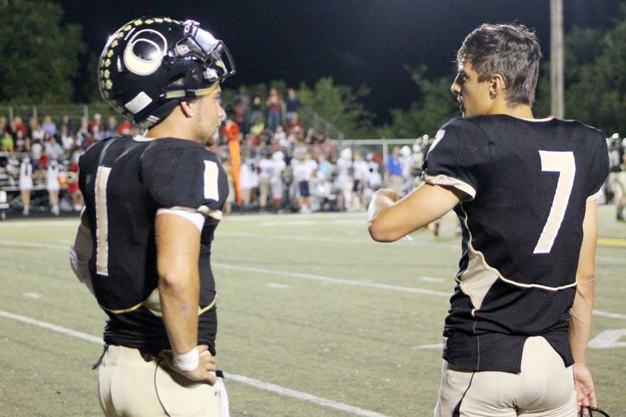 Senior co-quarterbacks Kobe Allen (left) and Bailey Vuylsteke talk on the sidelines during the Tigers 27-0 rout of Parkway South in the varsity teams home opener on August 21.