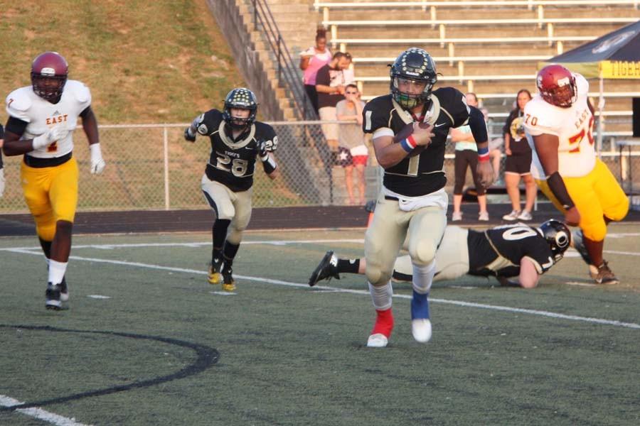 Co-quarterback Kobe Allen (12) runs for an 11-yard touchdown in the first minute of the Tigers game against Hazelwood East on Friday, Sept. 4. Allen later got hurt and was unable to finish the game.