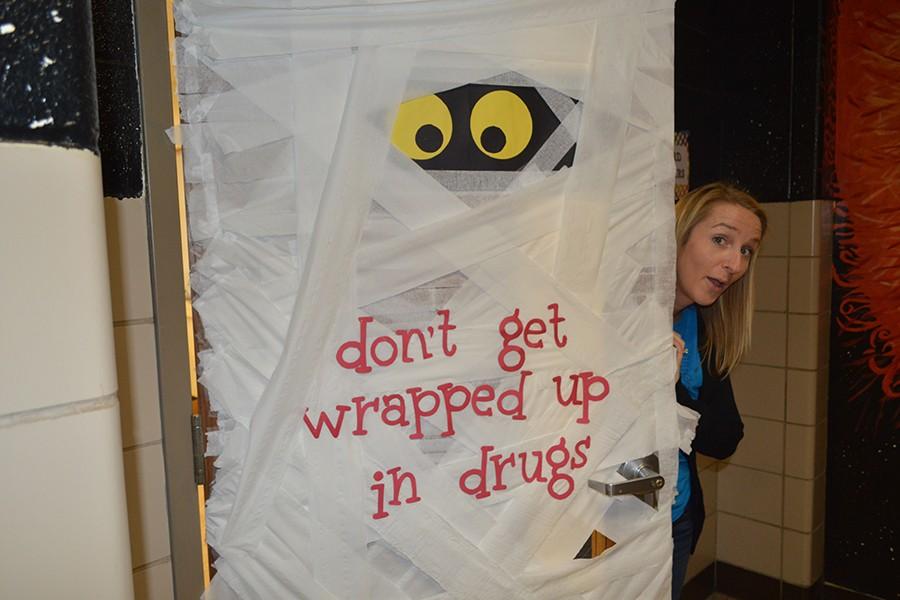 A teacher poses behind her ANPs decorated door.