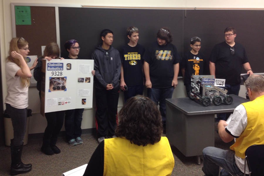The robotics team stands with their robot.
