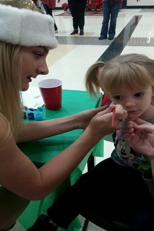 A Golden Girl paints a childs face at the second annual Breakfast with Santa.