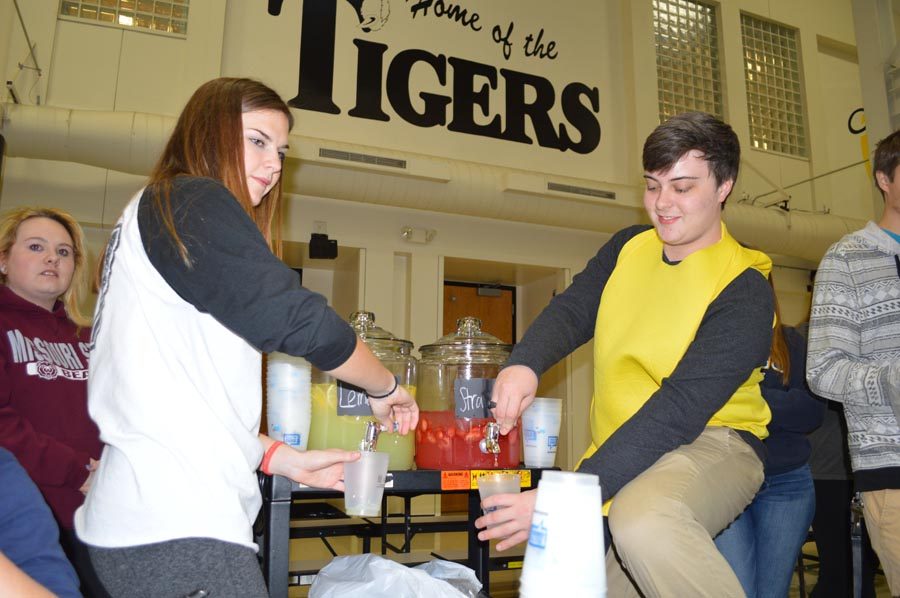 Pouring lemonade, Victoria Ratcliff (12) and Matt Argent (12) help run their lemonade stand making $60 in profit.