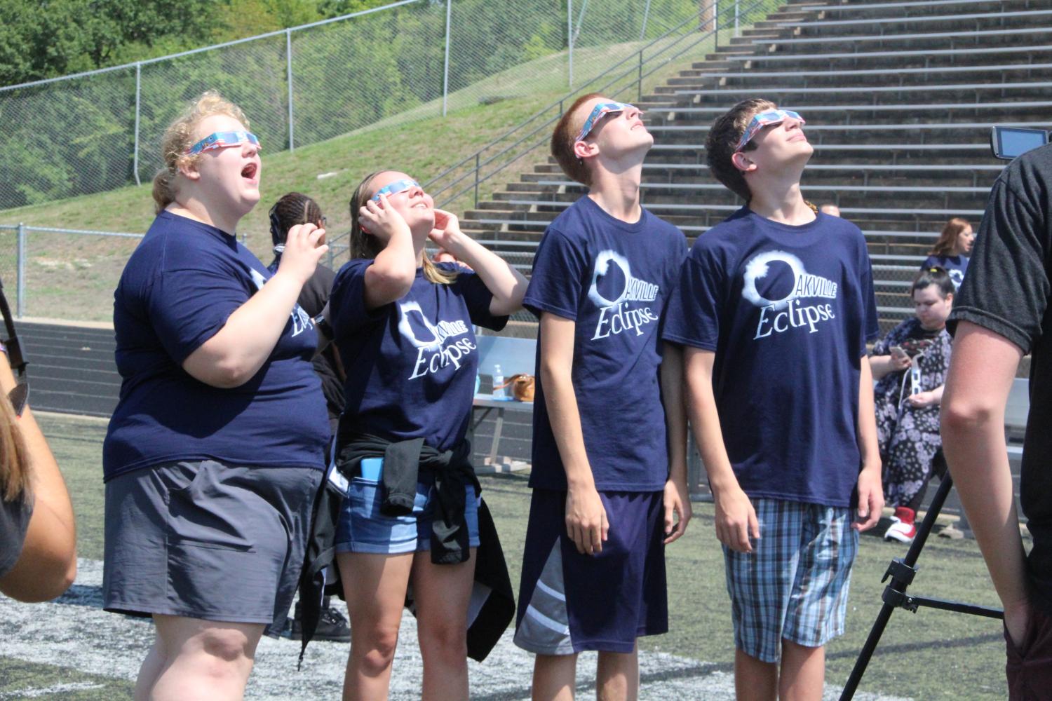 Wearing their eclipse shirts, a group of students looks up mesmerized by the eclipse.