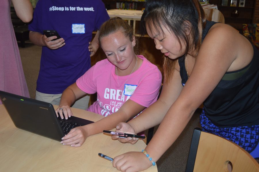 Student body president Taylor Zapf (12) checks out the new app with STUCO member at STUCO meeting on Sept. 21.
