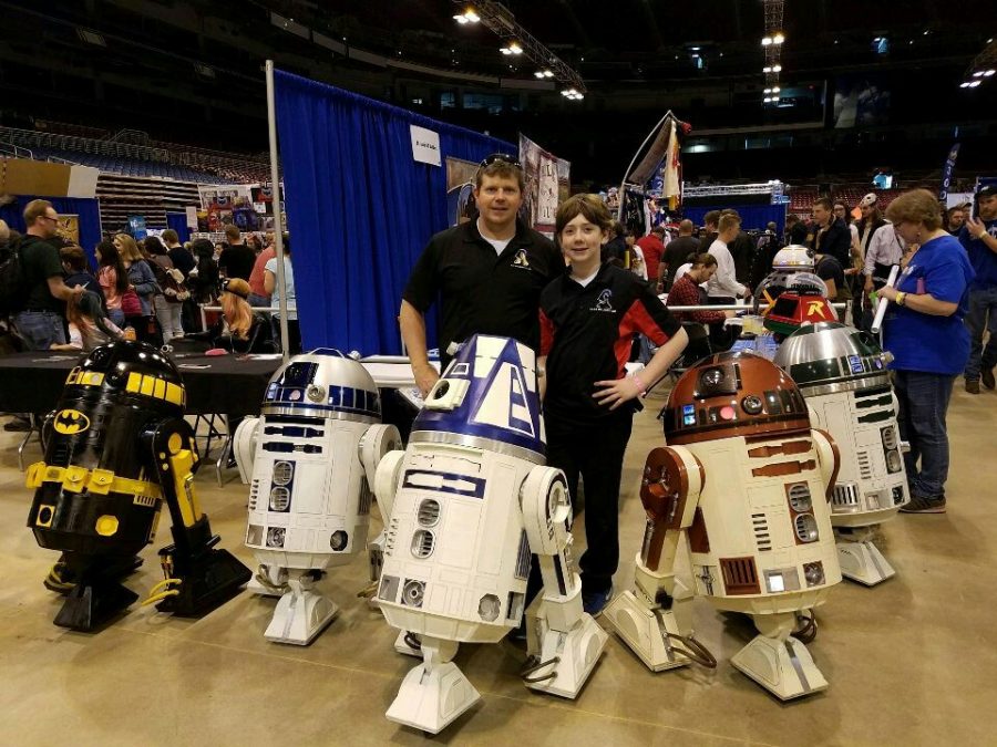 Crawford and his dad pose surrounded by droids at Wizard World.