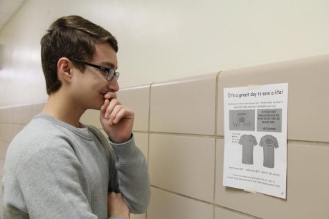 French student analyzes flyer on the wall outside Room 235 on March 2.