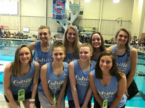 Posing for a picture in front of the pool, Hannah Baker (12), Chloe Dedic (12), Allison Schmitz (12), Casey Landmann (12), Sarah Daues (10), Maddie Poertner (10), Meg Heveroh (9), and Allison Streb (11) smile for a picture before competing on Feb. 16.
