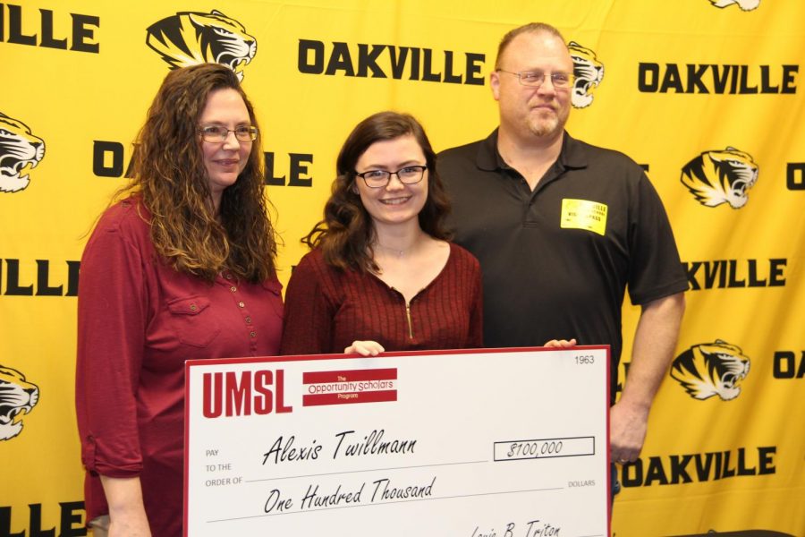 Lexi Twillmann (12) smiles with her big check from UMSL in the OHS library.