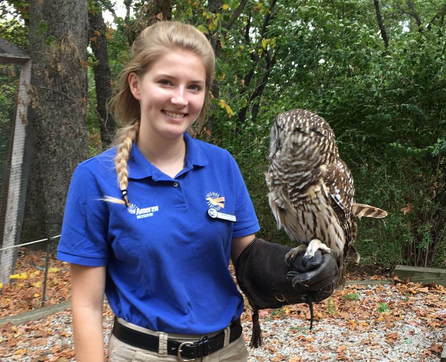 With an owl resting on her arm, Sabreena Leach (12) smiles for a picture while volunteering at the Wild Bird Sanctuary.