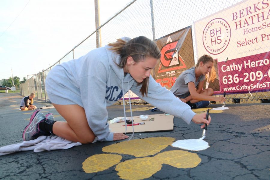Lauren Halamicek (12) paints her paw print on the blacktop behind the football field on Sept. 4.