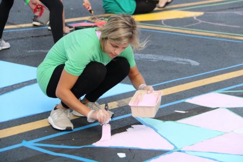  Courtney Doerr (12), who helped start the event, paints her parking spot. 