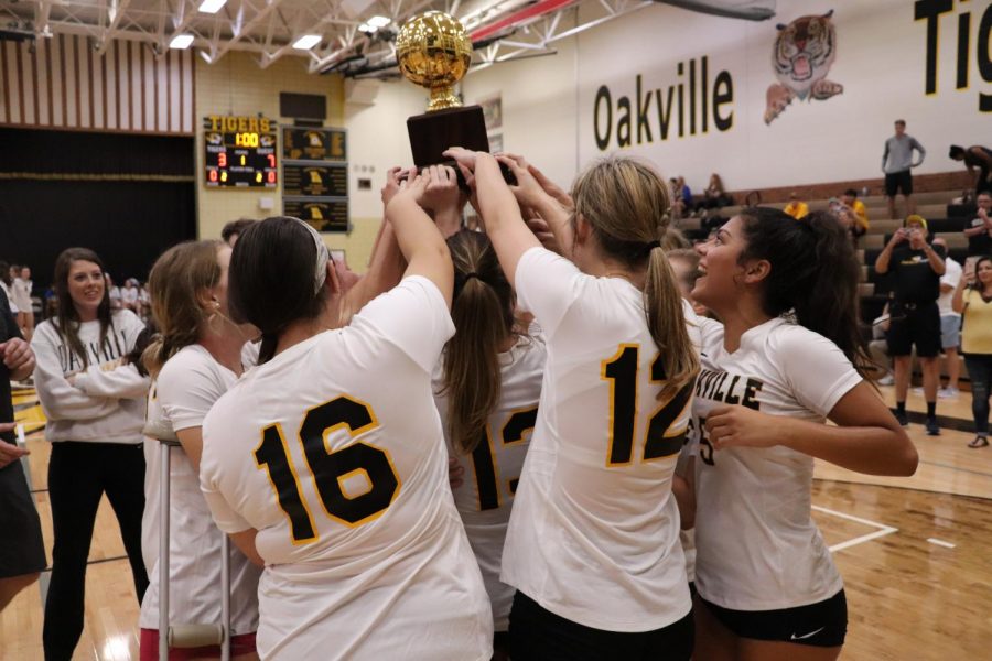 Varsity+girls+volleyball+holds+up+the+first+place+trophy+after+beating+Marquette+in+the+finals+of+the+Gateway+Matchup+tournament.