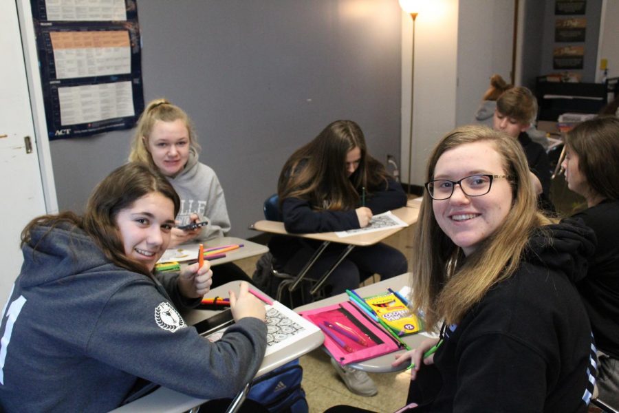 Allison Auer (9) and Sarah Hinkamp (9) color from pages in a coloring book in the Zen Coloring seminar in Mrs. Amy Creans room. This is from the first seminar day of semester two (Jan. 27).