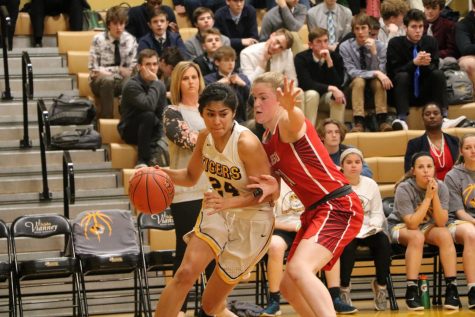 Angela Elguezabal (12) is guarded by a Cor Jesu defensemen as she dribbles the ball closer to the basket.
