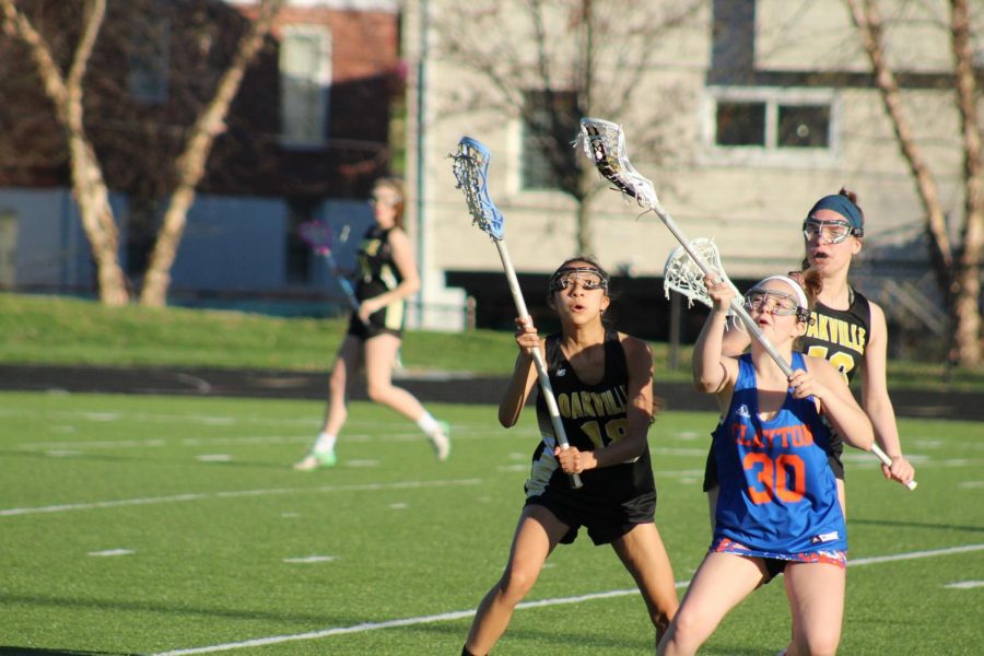 Kaylene Nguyen (11) secures the lacrosse ball in her stick at a game versus Clayton.