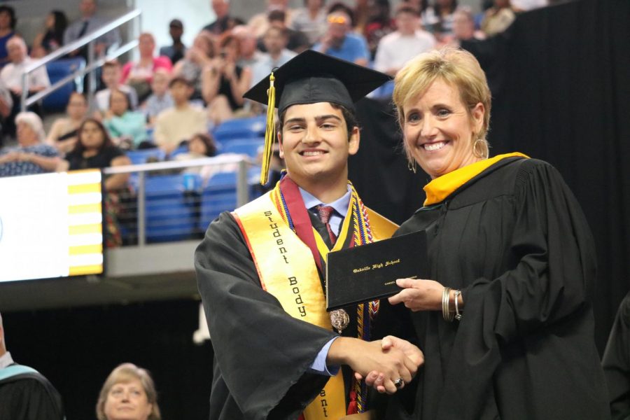 Last+years+graduation+ceremony+was+held+at+Chaifetz+Arena%2C+the+first+OHS+graduation+ceremony+ever+held+at+the+arena+on+the+St.+Louis+University+campus.+This+is+Sam+Gandhi+accepting+his+diploma+from+Mrs.+Peggy+Hassler+of+the+Mehlville+Board+of+Education.+Sam+was+the+2019+Student+Body+President.