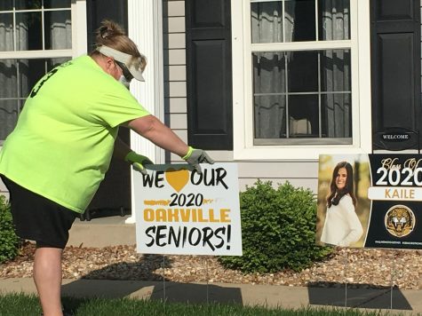 Mrs. Jackie Neeley placing a senior yard sign on the lawn of Kaile Kalton. Teachers delivered signs to all seniors on Saturday, May 2, as part of the OHS Yard Sign Brigade.