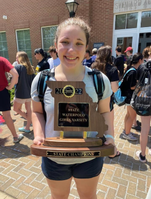 Mallory Guentz (11) poses for a photo with the state trophy at the 2022 State Water Polo Championship. We did amazing,  Guentz said. We all worked so hard.” The team won against Marquette, the team which they lost to at last years state competition. 
