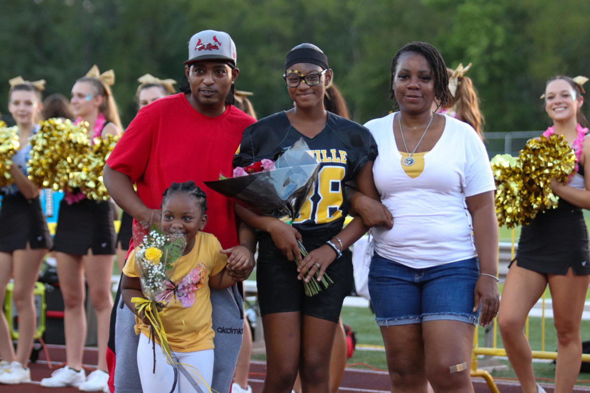 Myesha Dickens (12) walks down the track with her family during football’s Senior Night. “It was really cool being recognized and having a lot of people supporting me for my decision,” Dickens said. Though she was worried of what everyone would think, Dickens has had a great experience on the team and only regrets waiting to do so. 