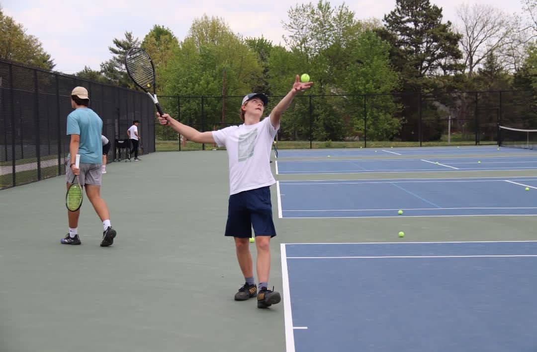 Josh Tiemann (12) throws the ball up in the air as he prepares to serve during tennis practice at Bernard Middle School. I was number one freshman and junior year and hopefully senior year… Tiemann said. Tiemann has played tennis for nine years. 