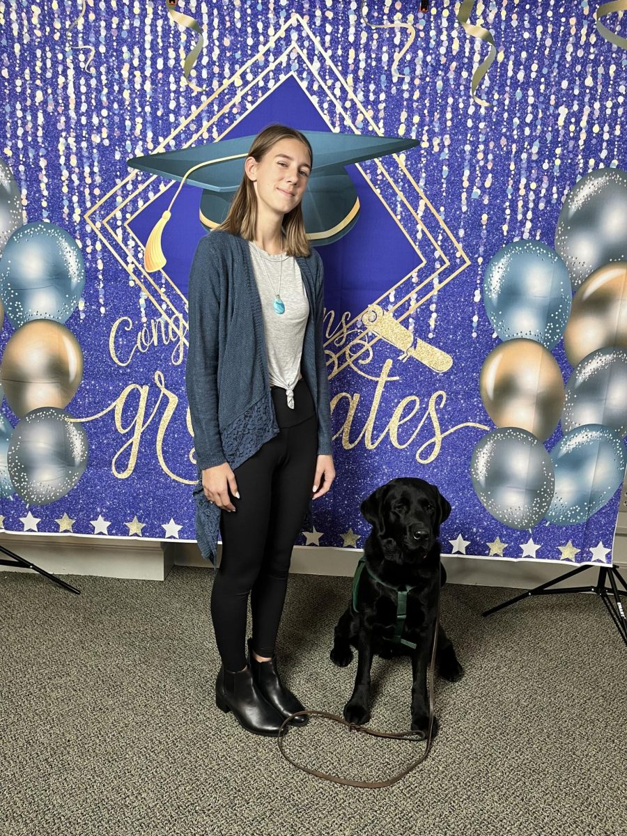 Kelley Akers (11) poses next to her most recent service dog, Giroux, on Dec. 2, 2023 at his graduation. It is a happy feeling that they are going to a good place and doing something good, Akers said. Akers favorite memory with Giroux was when he was a puppy.