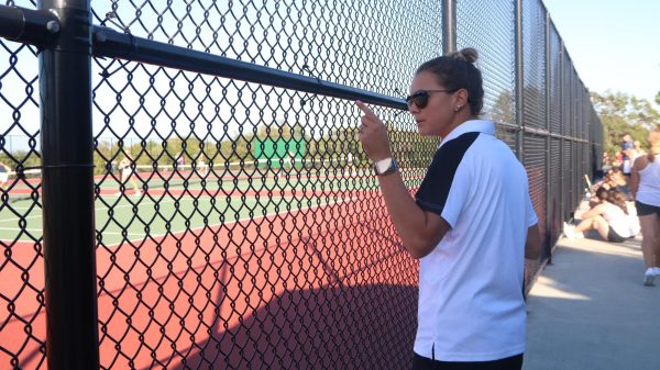 Assistant tennis coach, Shelby Enright, counts how many players are on the court during a match against Parkway West on Sep. 28. “My favorite thing about coaching is watching the players grow and getting to help them learn the sport,” Enright said. Enright said she enjoys cheering on the players and being there to support them.