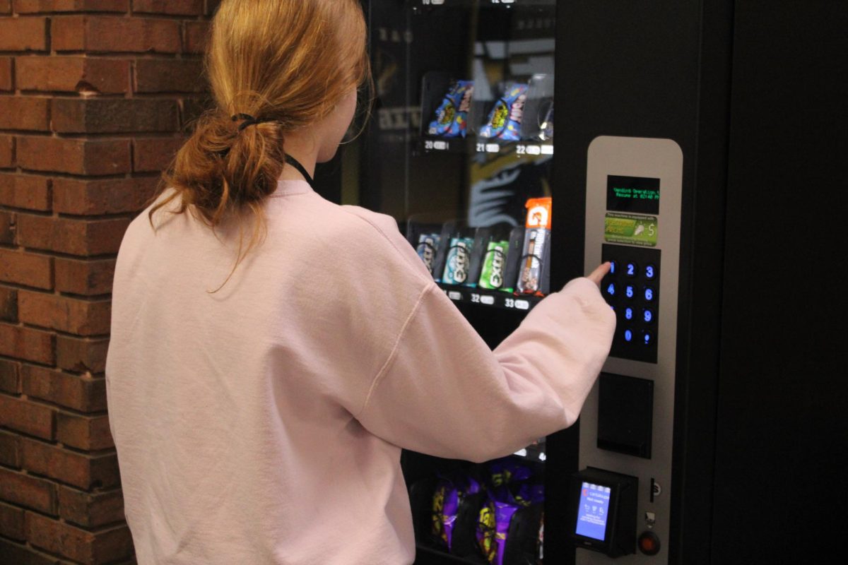 Mady Donze (10) buys a snack from the vending machine that the Marketing II students run.