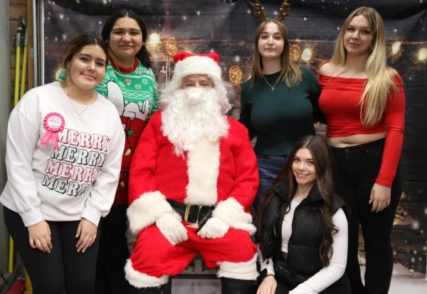 Members of FCCLA pose for a photo with Santa at Pet Supplies Plus. "I normally help out by taking pictures of the pets for Presents for Paws," Elle Randolph (10) said. Randolph is an FCCLA regional officer.