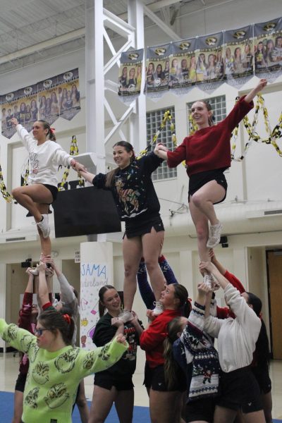 Mungle practices a stunt with the cheerleading team while the bases work together to keep the flyers in the air. “I’m excited because I’ve never done it (competed) before,” Mungle said. Even with the stress of staying flexible and working harder, Mungle looks forward to competing for the new experience.