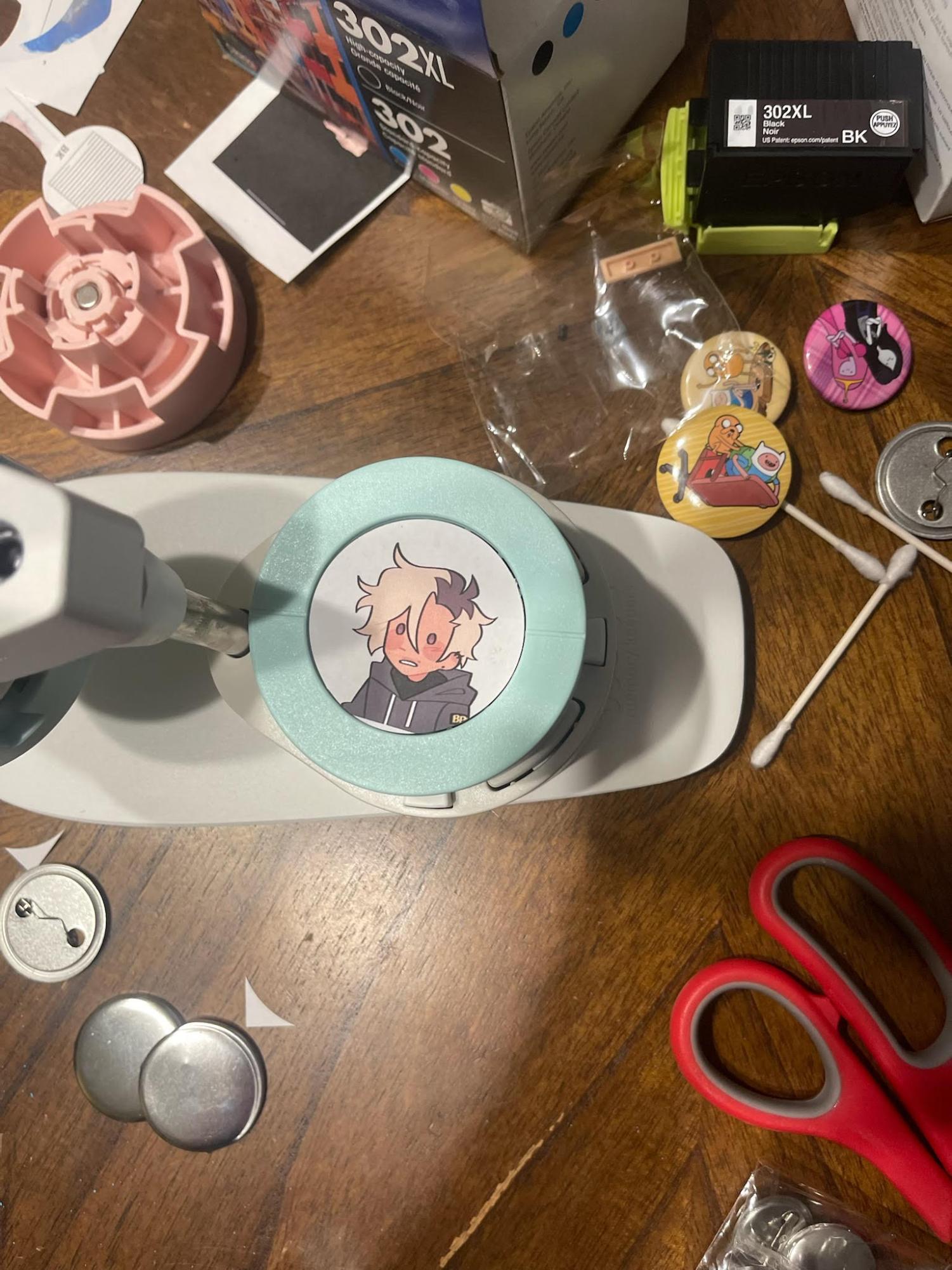 Henry Allison (9) shows his workplace where he produces buttons. “It can be somewhat hard to make these buttons,” Allison said. “It can take some precision to cut the pieces correctly.” Allison produced a commission of his medium size, consisting of four different buttons.

